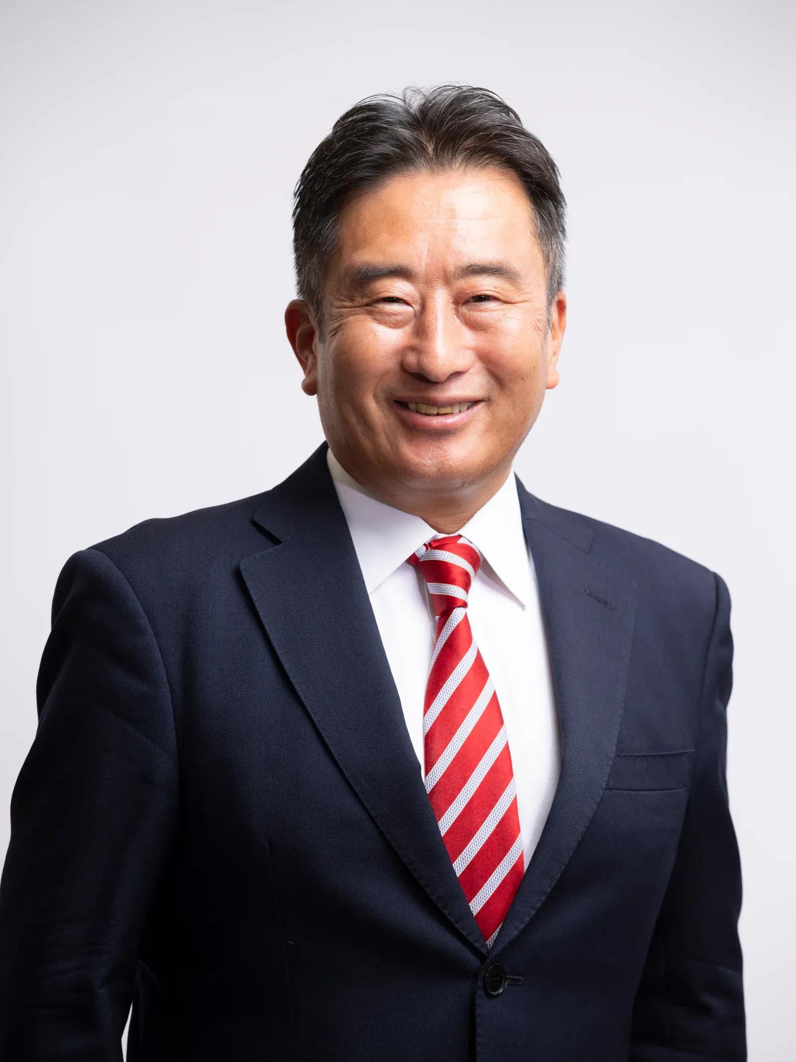 スーツ姿で笑顔を見せる田中真一